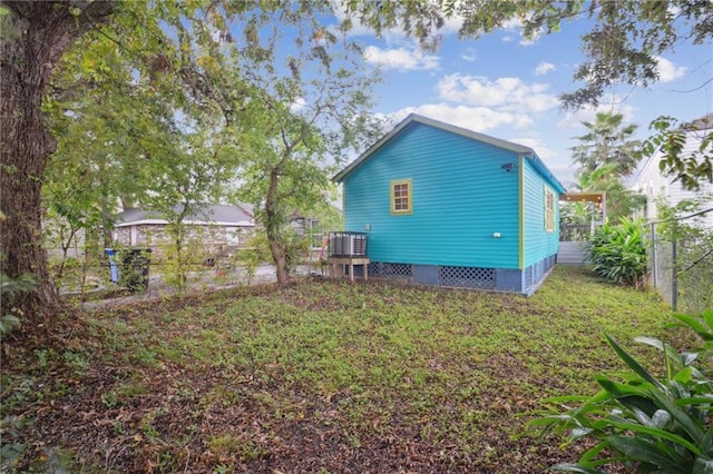 back of property featuring central air condition unit and a lawn