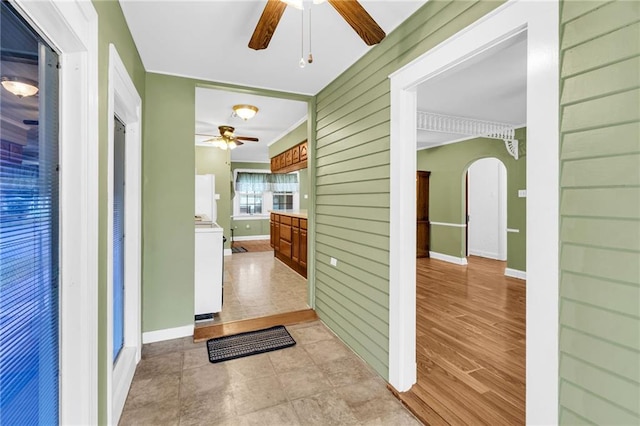 hall with wood walls, light wood-type flooring, and washer / clothes dryer