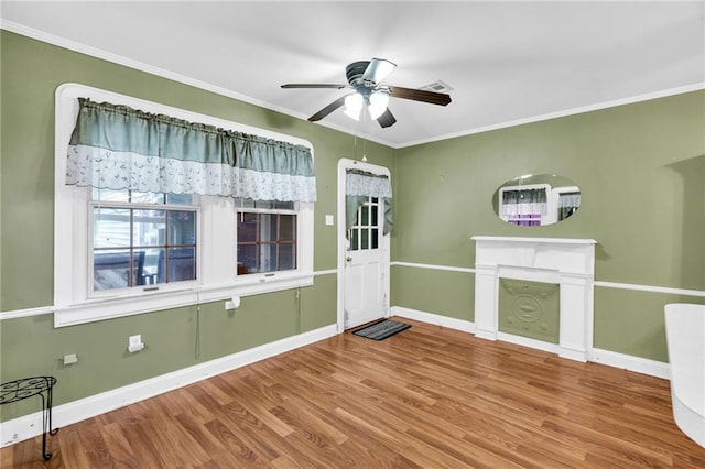 interior space featuring ceiling fan, wood-type flooring, and ornamental molding