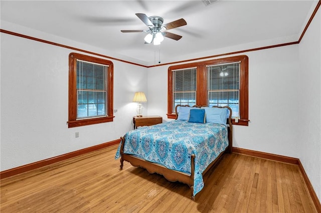 bedroom with hardwood / wood-style floors, ceiling fan, and crown molding