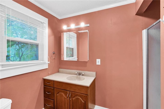 bathroom featuring toilet, vanity, a shower with door, and ornamental molding