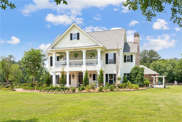 view of front facade with a front lawn and a balcony