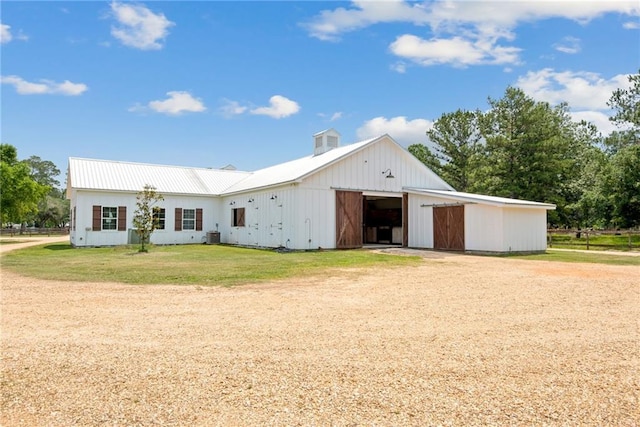 view of front of home with an outdoor structure and a front lawn