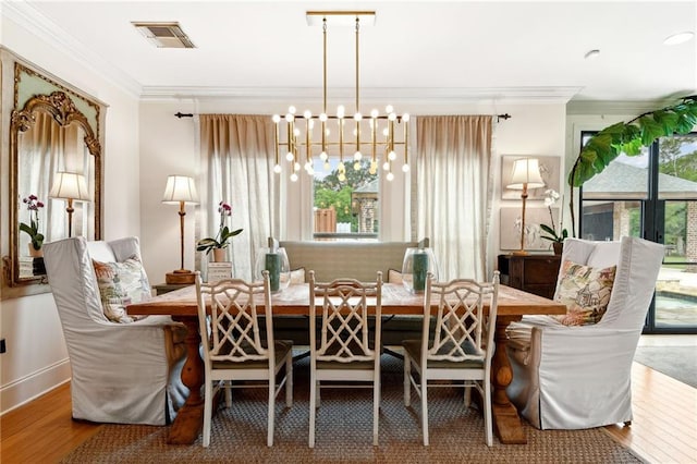 dining space featuring a wealth of natural light, wood-type flooring, a notable chandelier, and ornamental molding