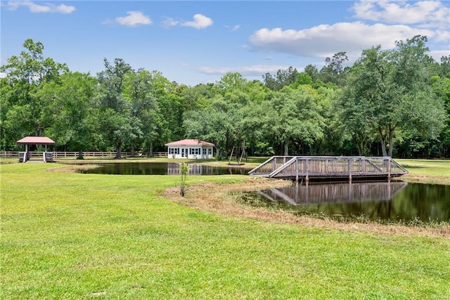 surrounding community featuring a water view and a lawn