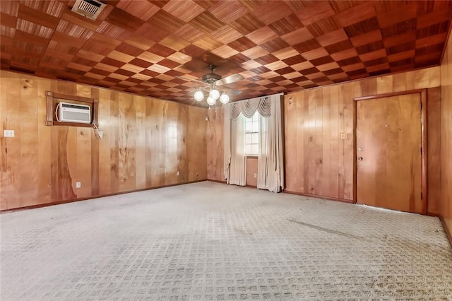 carpeted empty room featuring wooden ceiling, ceiling fan, and wooden walls