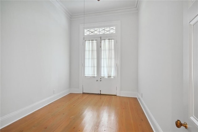 spare room with light hardwood / wood-style flooring and crown molding