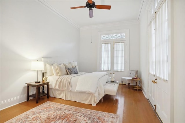 bedroom with ceiling fan, crown molding, and wood-type flooring