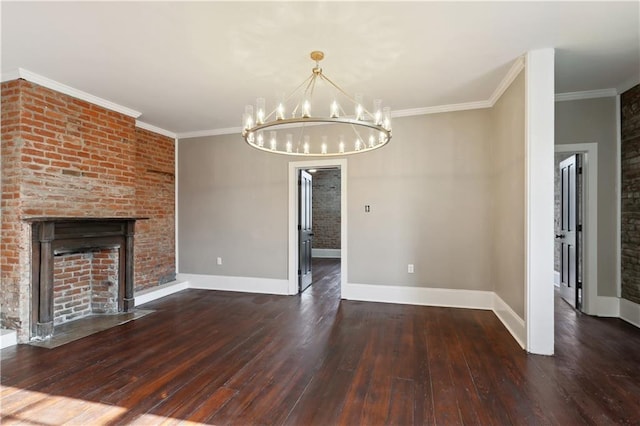 unfurnished living room with dark wood-type flooring, an inviting chandelier, ornamental molding, and a brick fireplace