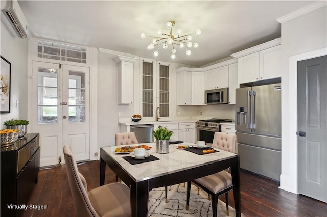 kitchen featuring white cabinetry, a wall unit AC, an inviting chandelier, high quality appliances, and dark hardwood / wood-style flooring