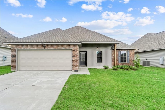 view of front of house with a front lawn, central air condition unit, and a garage