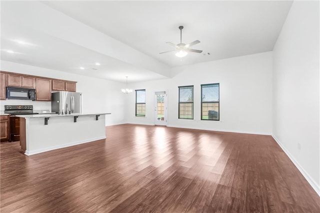 unfurnished living room featuring dark hardwood / wood-style floors and ceiling fan with notable chandelier