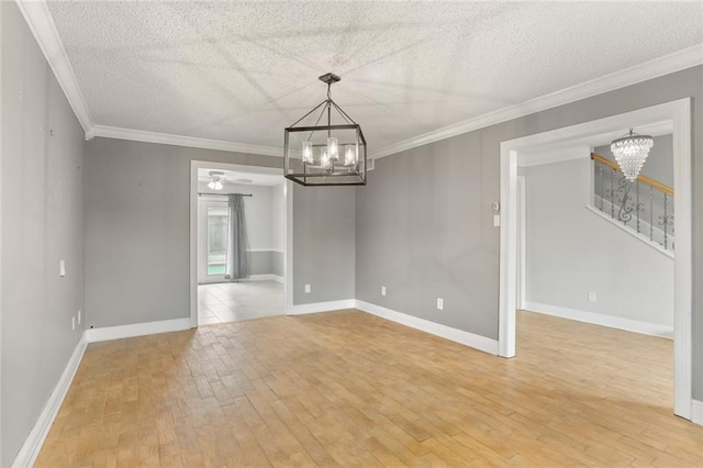 empty room with ceiling fan with notable chandelier, a textured ceiling, light hardwood / wood-style flooring, and crown molding