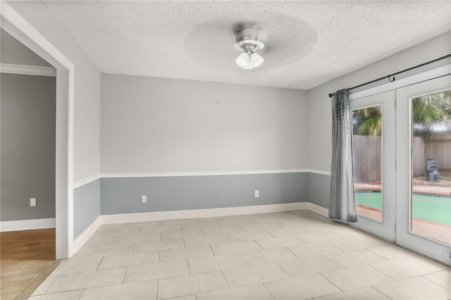 tiled empty room featuring a textured ceiling and ceiling fan