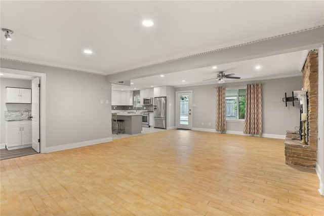 unfurnished living room featuring light wood-type flooring and ceiling fan