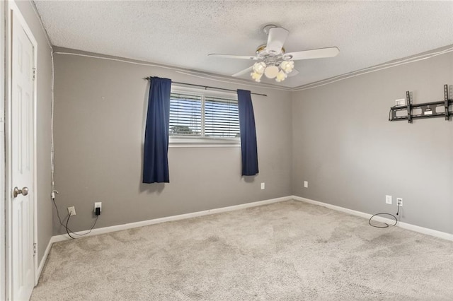 carpeted empty room with a textured ceiling, ornamental molding, and ceiling fan