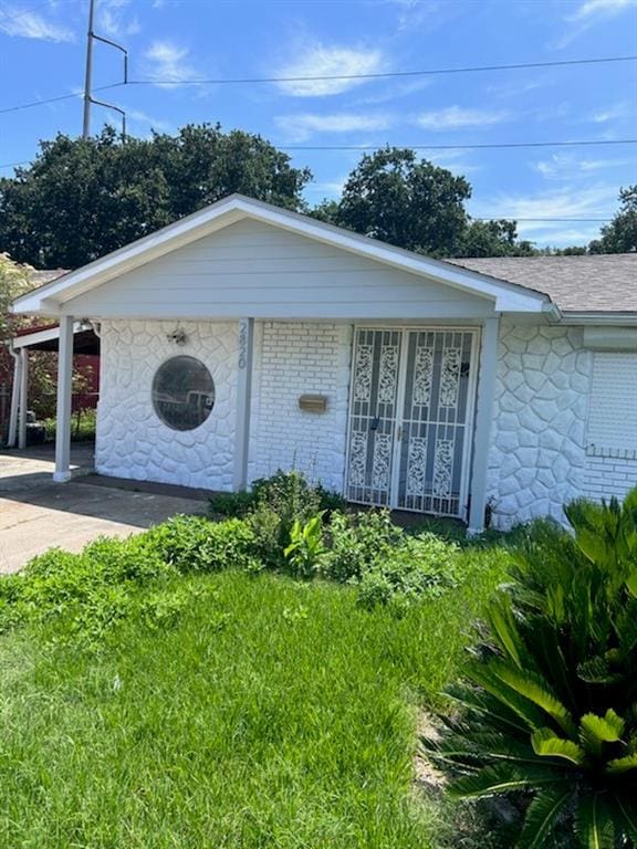 view of side of home with a yard and a carport