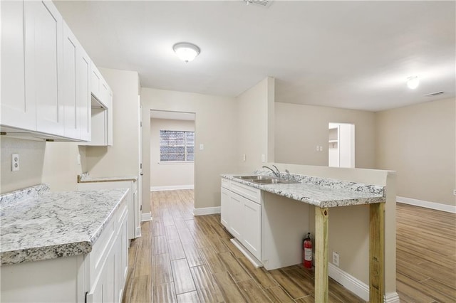 kitchen featuring white cabinetry, sink, and a kitchen island