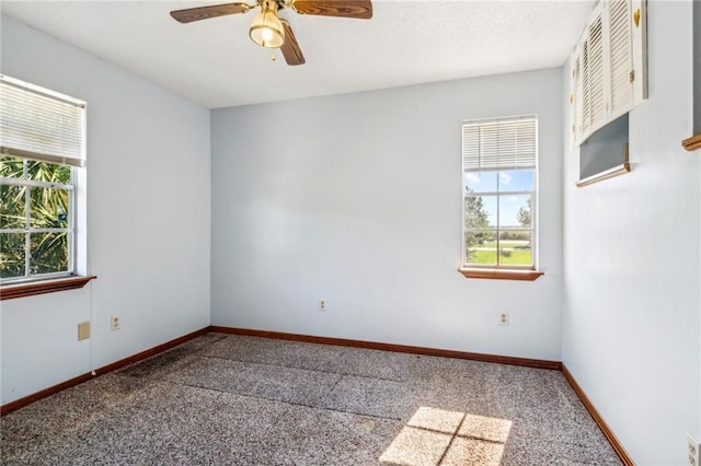 spare room featuring carpet flooring, a wealth of natural light, and ceiling fan