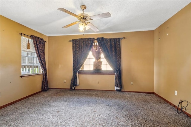 empty room with ceiling fan, a textured ceiling, and carpet flooring