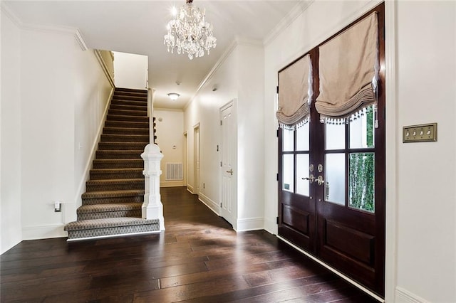 entryway featuring dark wood-type flooring, a chandelier, french doors, and crown molding