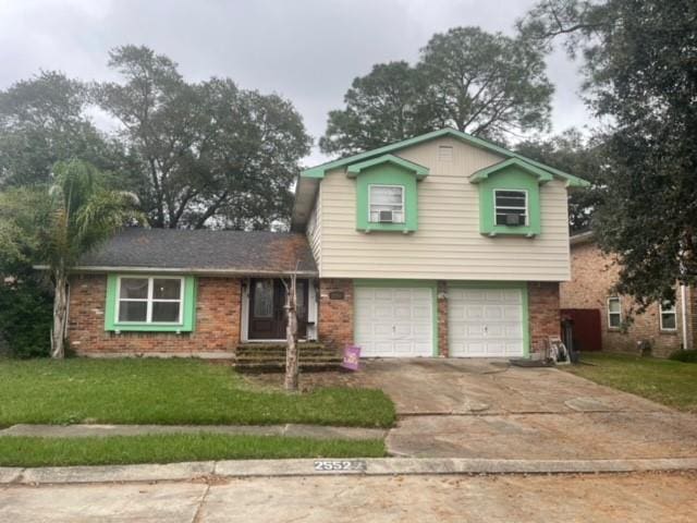 tri-level home featuring a garage and a front lawn