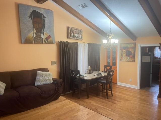 dining area with hardwood / wood-style floors, vaulted ceiling with beams, and an inviting chandelier