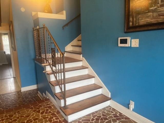 stairway featuring a towering ceiling