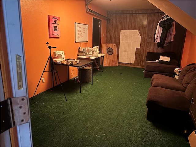 living room with dark carpet and wooden walls