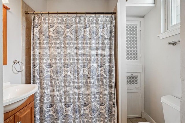 bathroom with curtained shower, vanity, and toilet