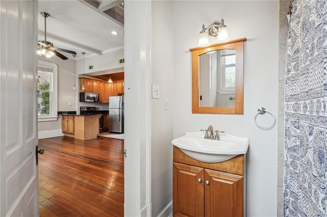 bathroom featuring vanity, hardwood / wood-style floors, ceiling fan, and beam ceiling