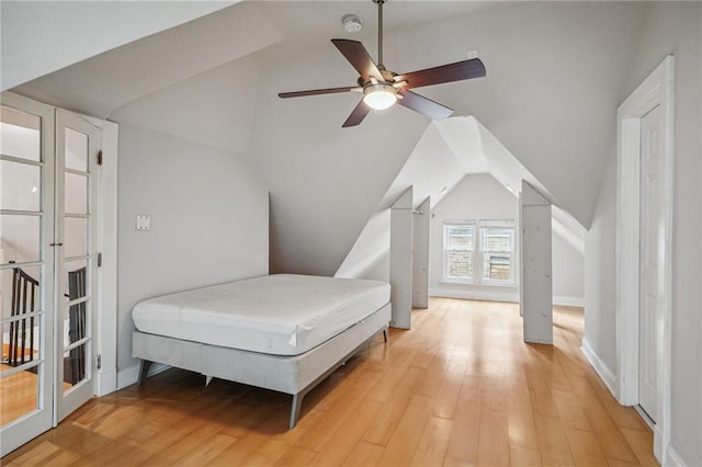 bedroom featuring light wood-type flooring, lofted ceiling, and ceiling fan