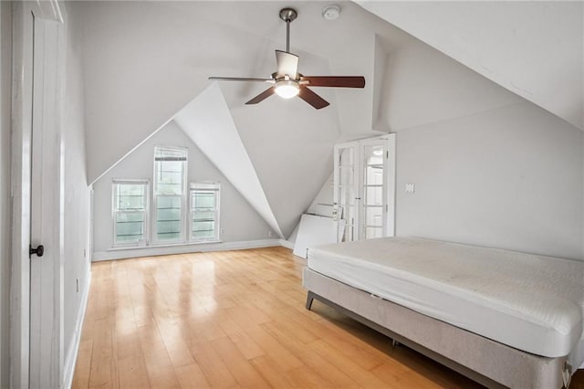 unfurnished bedroom with lofted ceiling, ceiling fan, and light hardwood / wood-style flooring