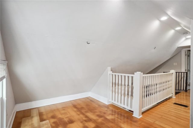 additional living space featuring lofted ceiling and wood-type flooring