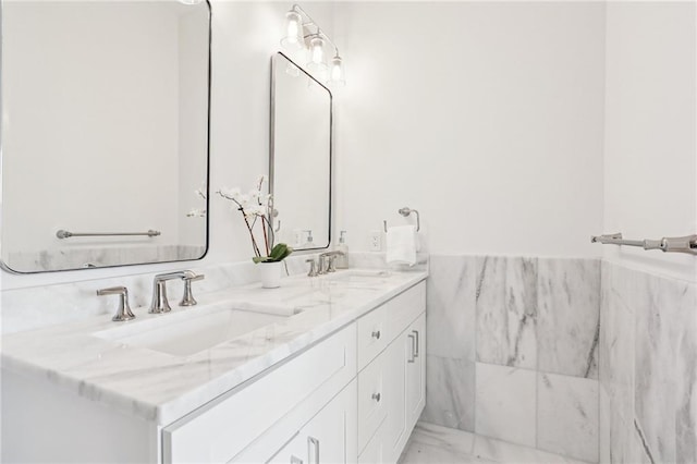 bathroom featuring vanity and tile walls