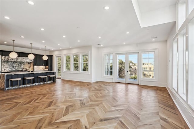 unfurnished living room featuring french doors and light parquet flooring