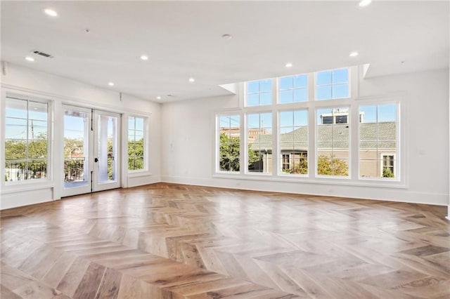 unfurnished room with light parquet flooring and a wealth of natural light