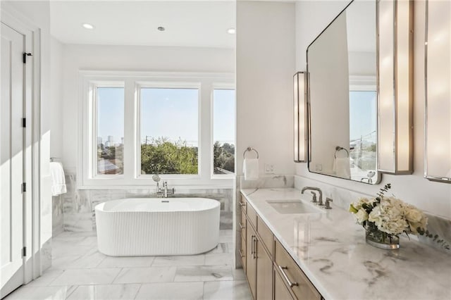 bathroom featuring vanity, a bath, and tile walls