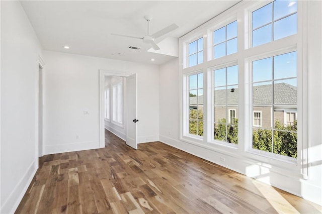 spare room with visible vents, baseboards, ceiling fan, and wood finished floors