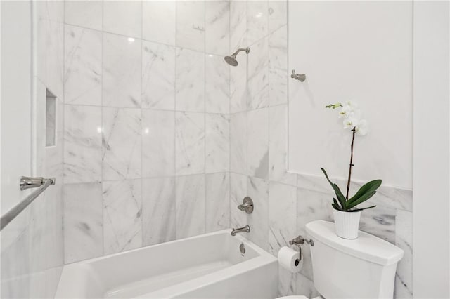 bathroom with tiled shower / bath combo and toilet