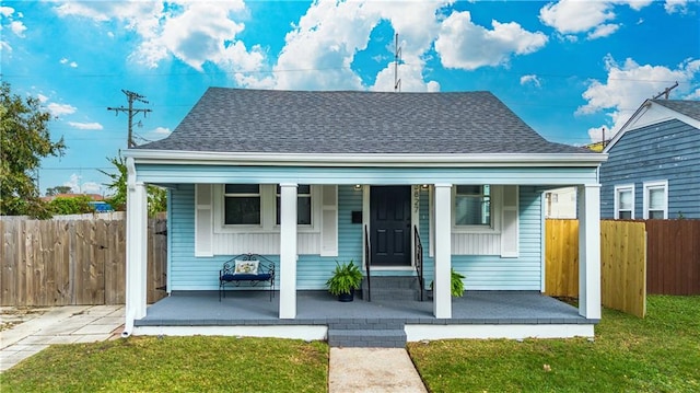 bungalow featuring covered porch and a front yard