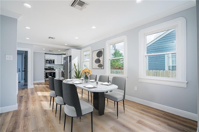 dining area with light hardwood / wood-style flooring and crown molding