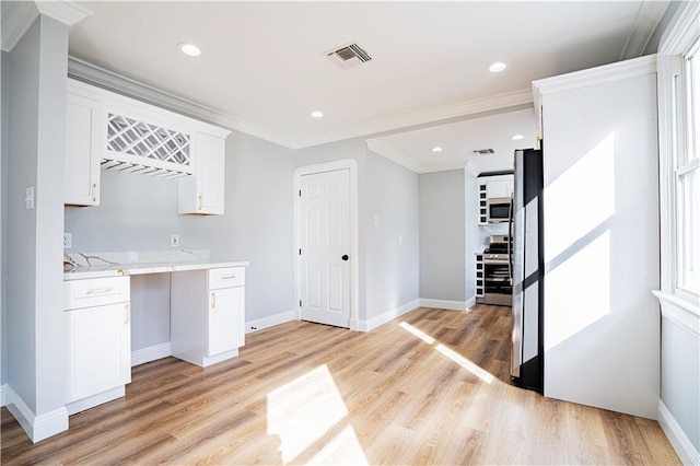 kitchen featuring white cabinetry, light wood-type flooring, appliances with stainless steel finishes, and crown molding