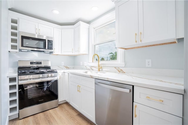 kitchen featuring light hardwood / wood-style floors, sink, appliances with stainless steel finishes, light stone countertops, and white cabinets