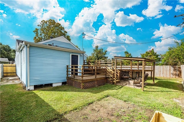 back of property featuring a lawn and a wooden deck