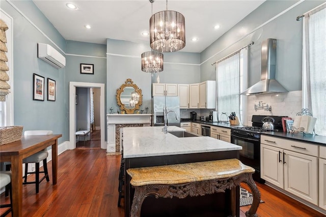 kitchen featuring sink, hanging light fixtures, stainless steel fridge with ice dispenser, wall chimney range hood, and black range