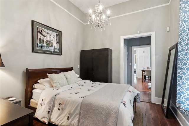 bedroom featuring dark wood-type flooring, a chandelier, and a towering ceiling