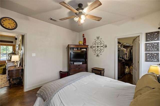 bedroom with a spacious closet, ceiling fan, and a closet