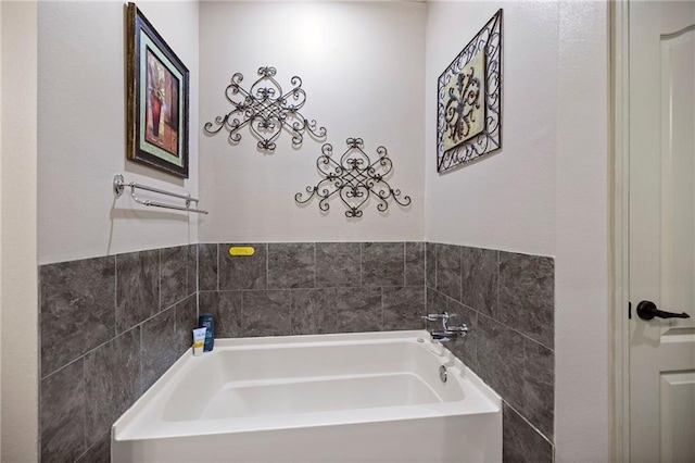 bathroom with tile walls and a tub