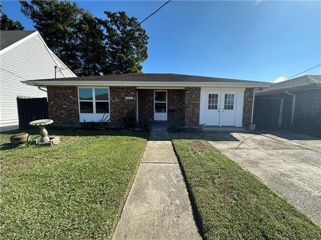 single story home with a front yard and a storage shed